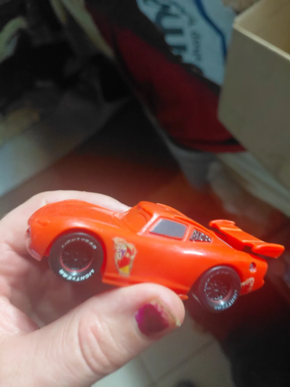 red Disney Pixar Lightning McQueen toy car, appearing to be a plastic model.